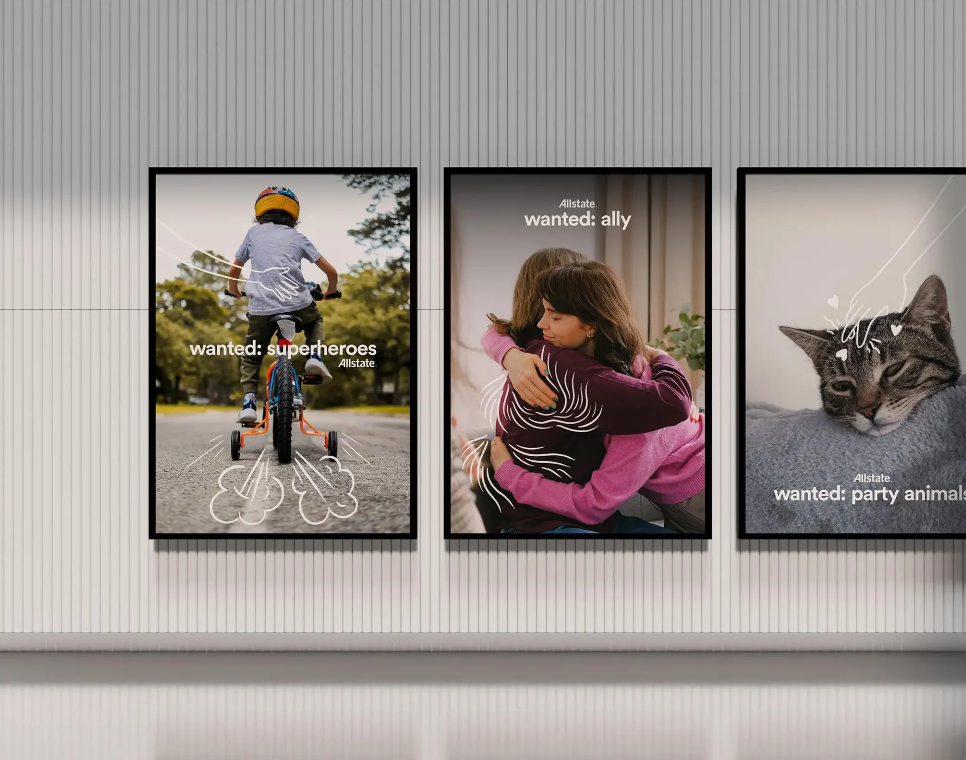 Three poster ads on a wall featuring a child on a bike, a hug, and a cat, with white line drawings.