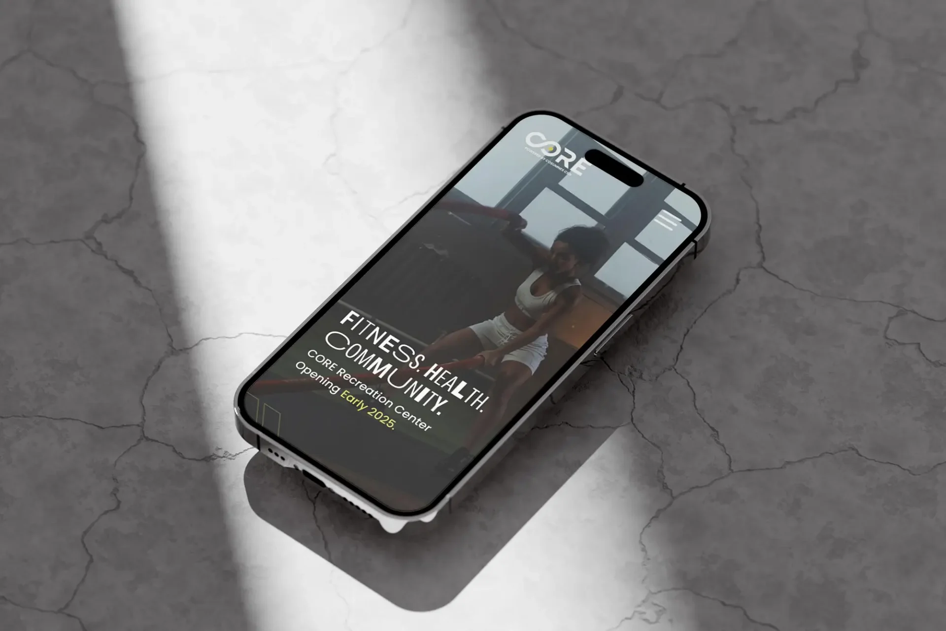 Smartphone mockup on a textured gray surface displaying a fitness app interface with the text "Fitness. Health. Community."