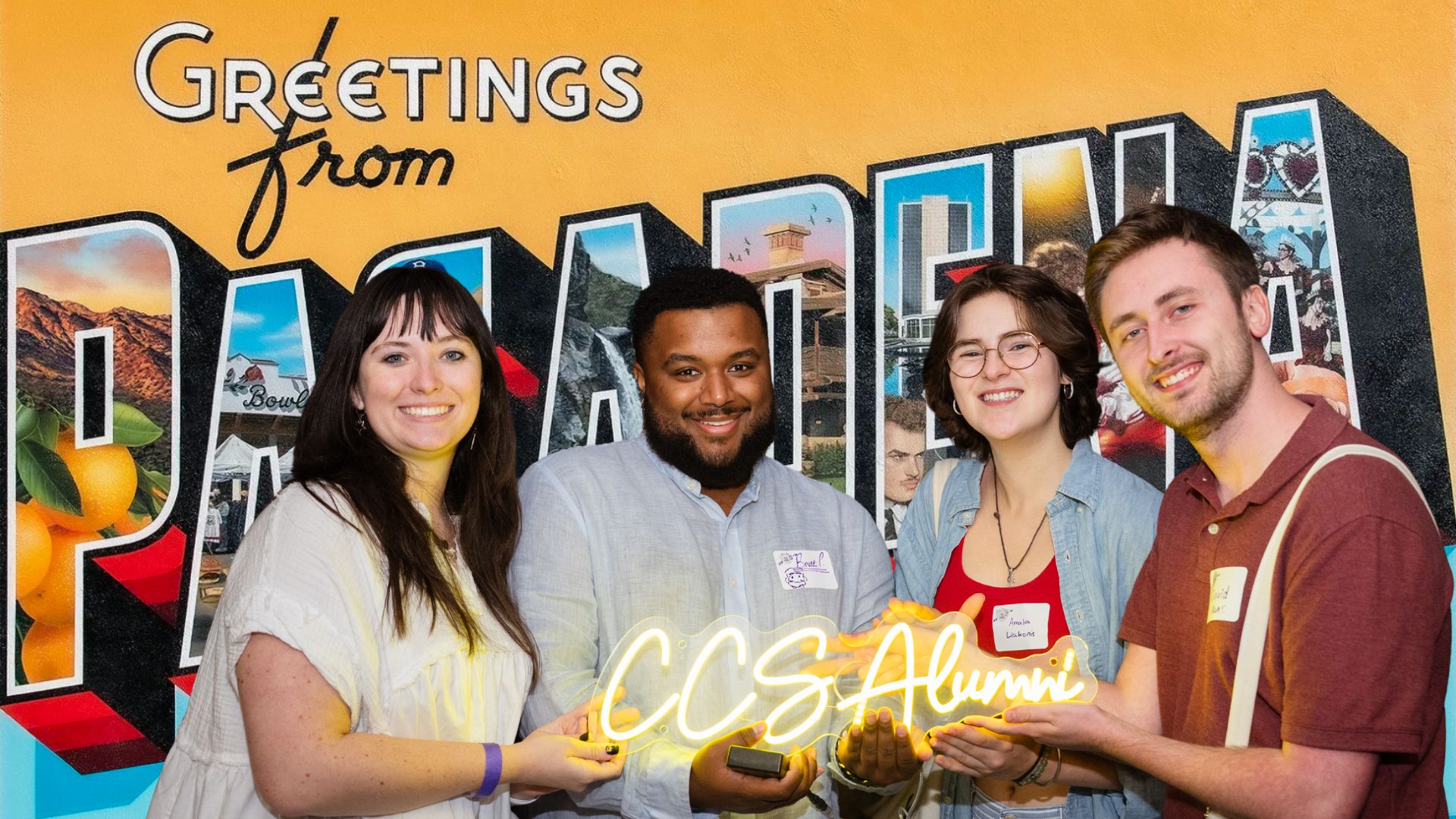 Four smiling alumni holding a glowing "����ר�� Alumni" sign in front of a "Greetings from Pasadena" postcard-style mural.