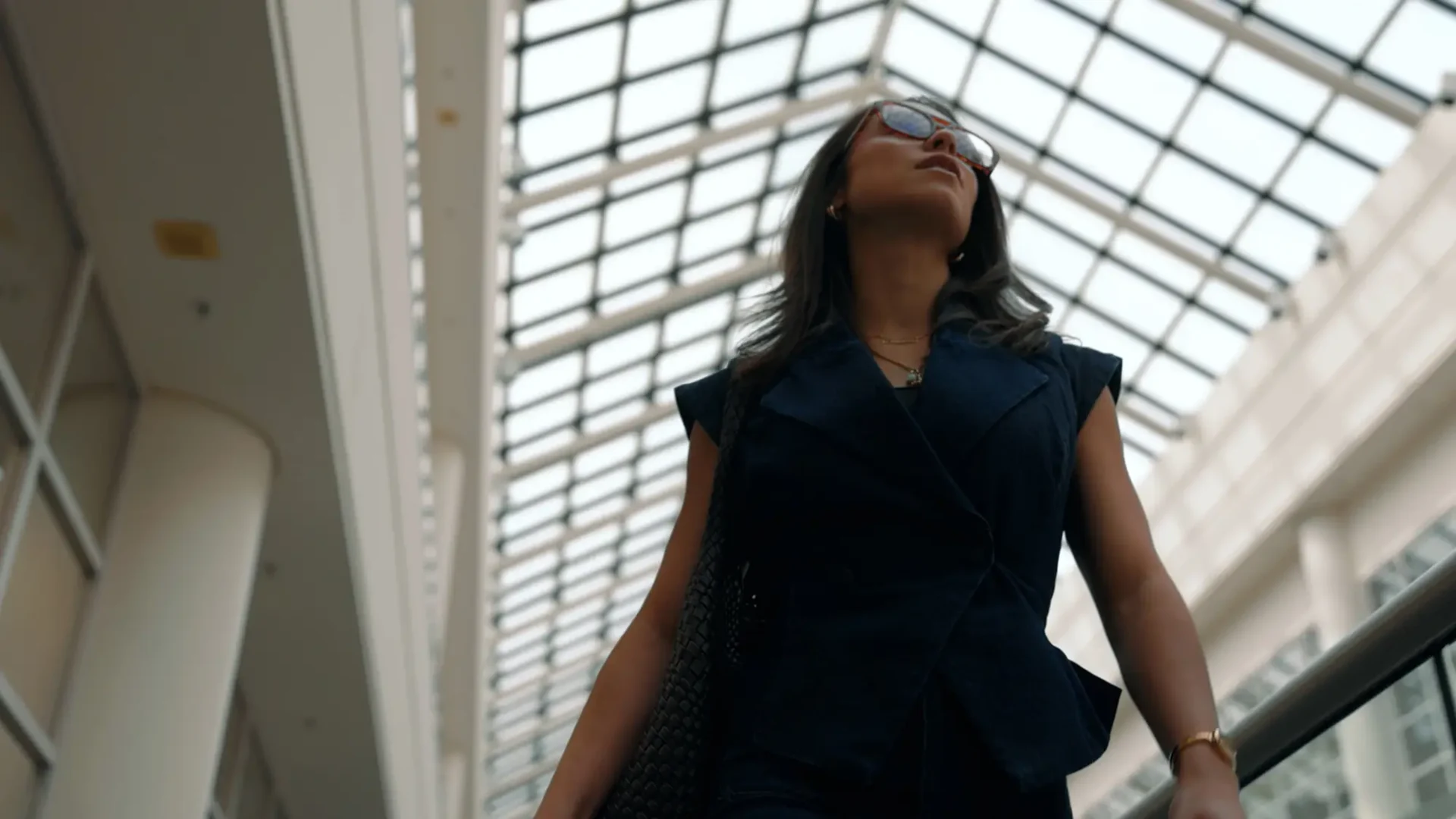 Christine Montalbano walking through the halls at Stellantis headquarters with white walls and a glass ceiling above her