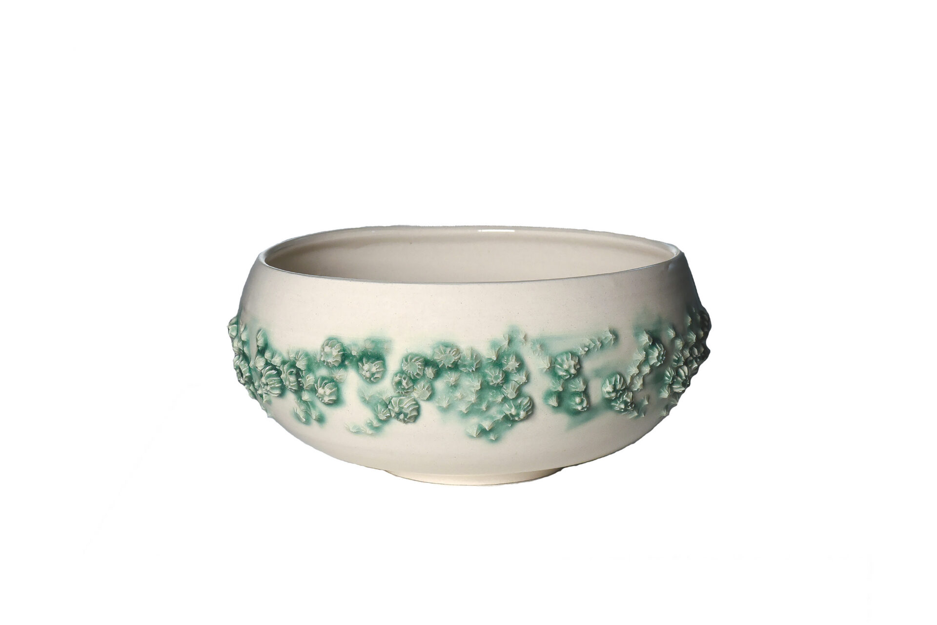 Off-white ceramic bowl with a textured, seafoam-green band of barnacle-like shapes around its center, set against a plain white background.