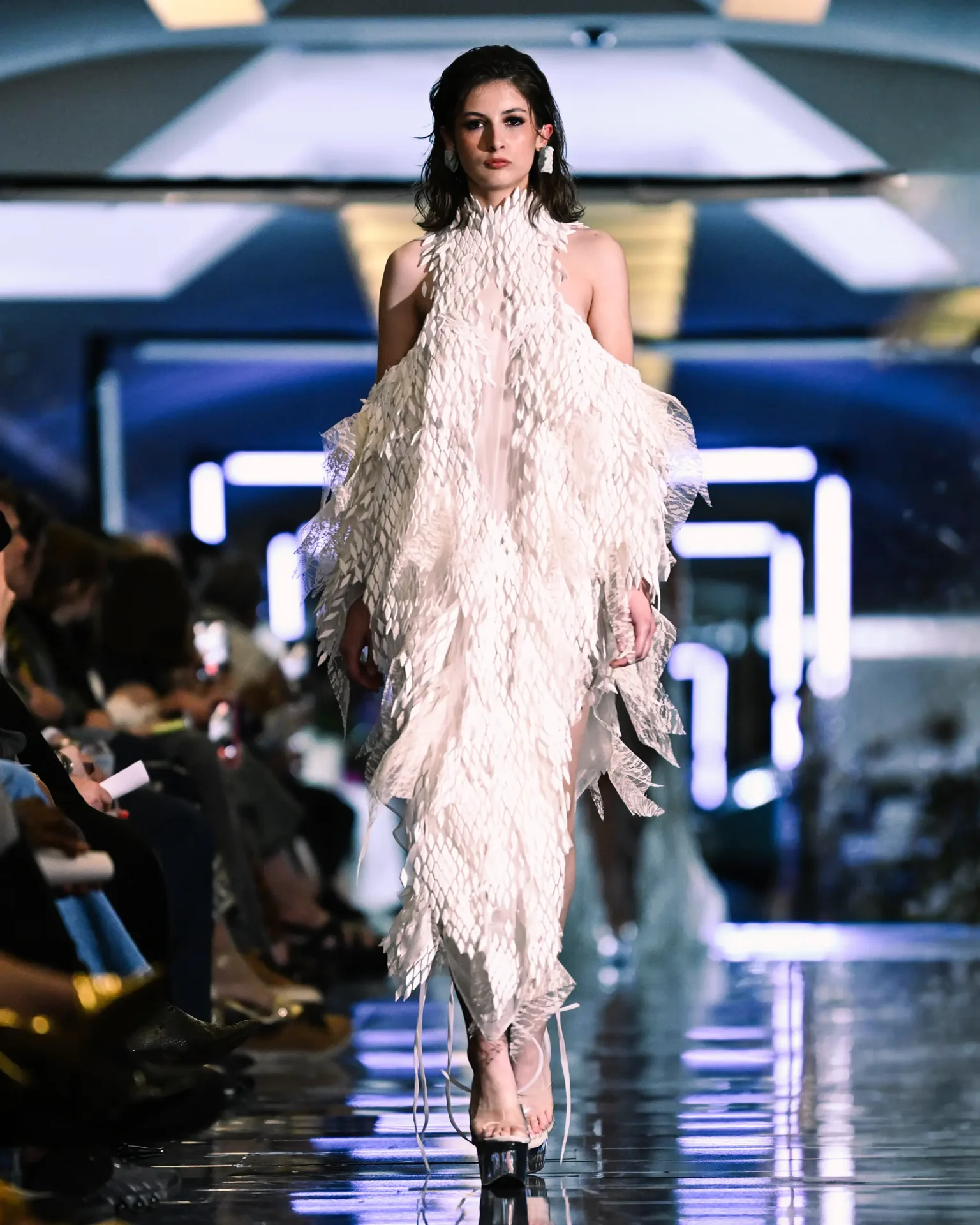 Model walking the runway wearing a white textured dress.