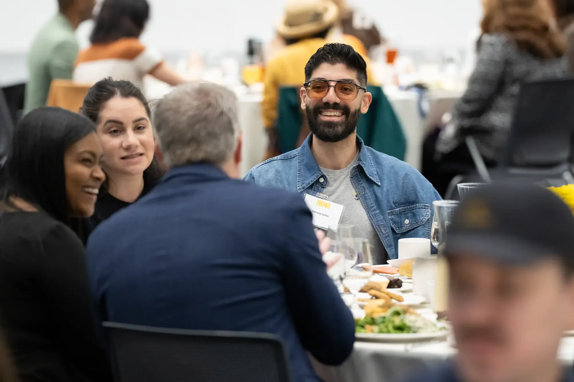 A table of people smile at the CCS Donor Appreciation Celebration.